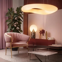 Fehér akril gyűrűs függő lámpa rózsaszín nappaliban fotel fölött