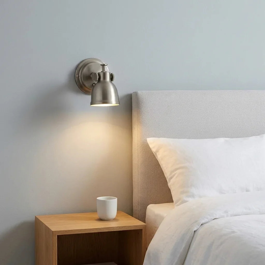 Bauhaus fali lámpa egy ágytámla fölött, olvasólámpaként