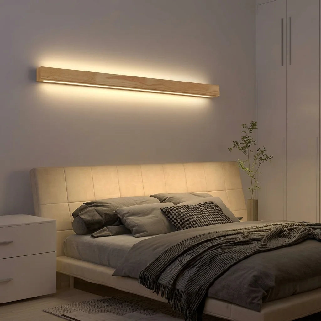 Hosszú fa LED fénypálca egy kárpitozott ágytámla fölött