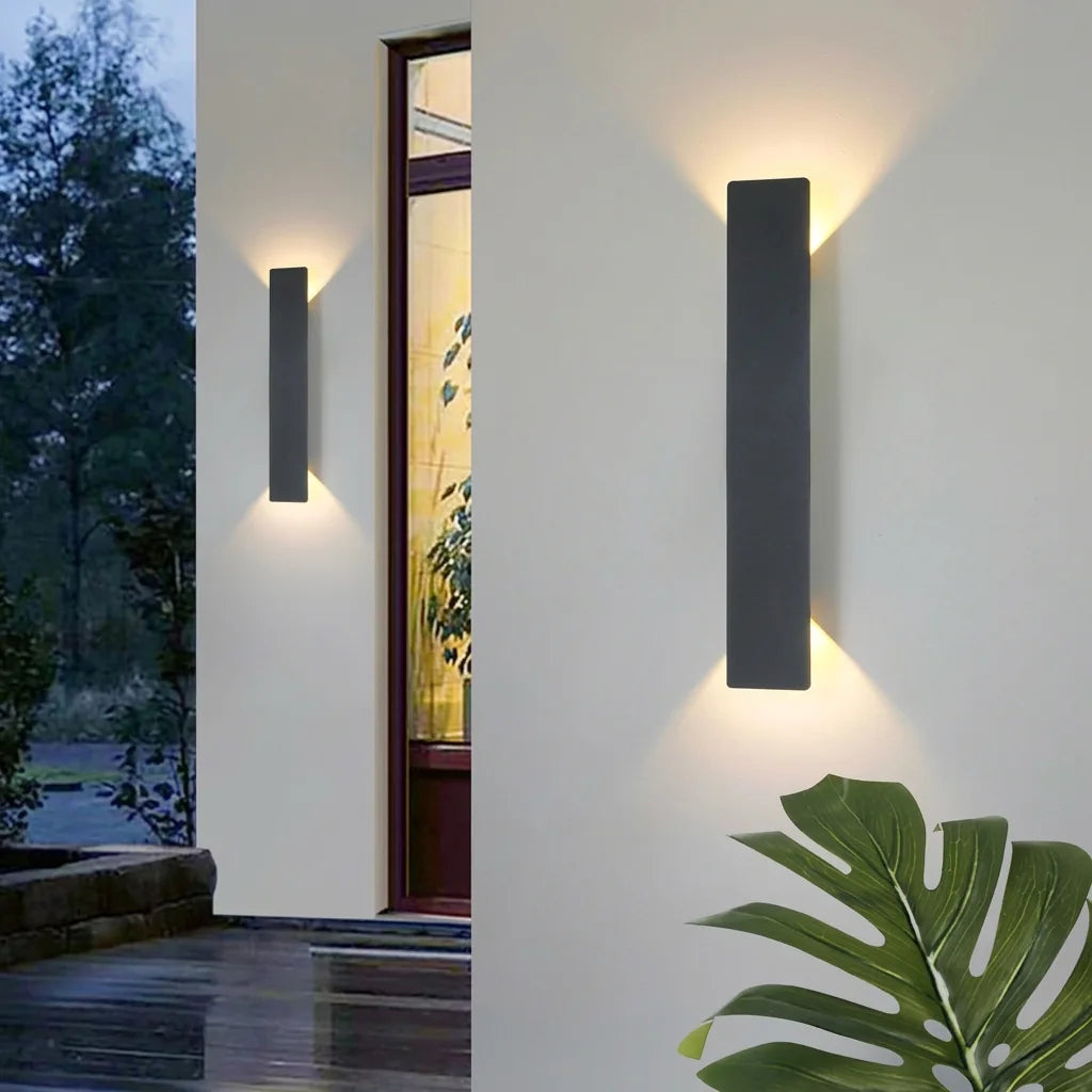 Fekete LED fénypengék egy fehér homlokzaton alkonyatkor