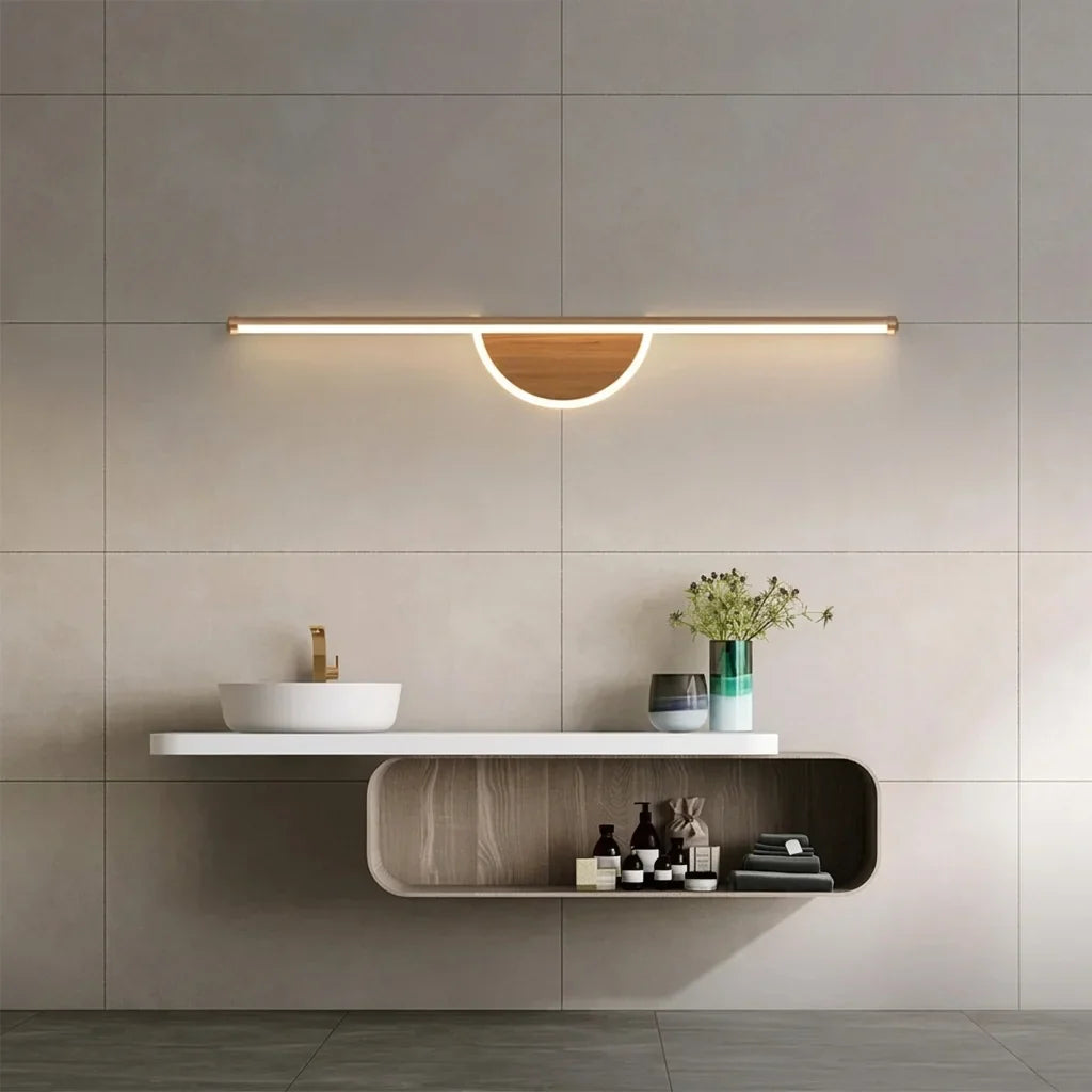 Félholdas LED fényrúd egy függesztett mosdópult fölött szürke csempén