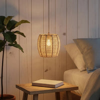 Ovális rattan lámpabúra az éjjeliszekrény fölött a hálószobában
