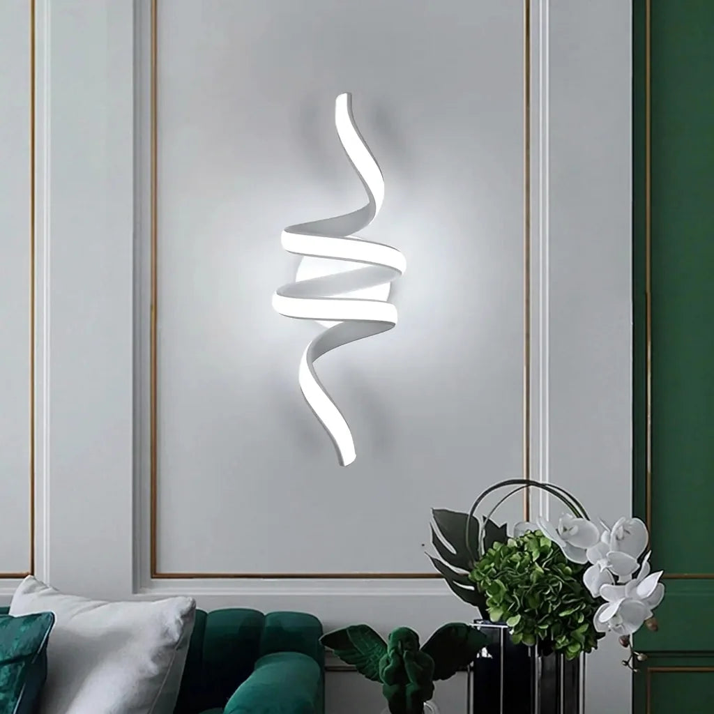 Fehér spirál LED fali lámpa egy stukkós falon egy zöld kanapé fölött