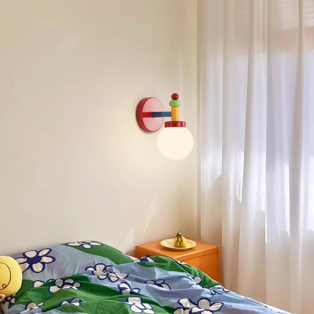 Világító többszínű lámpa egy narancssárga éjjeliszekrény fölött