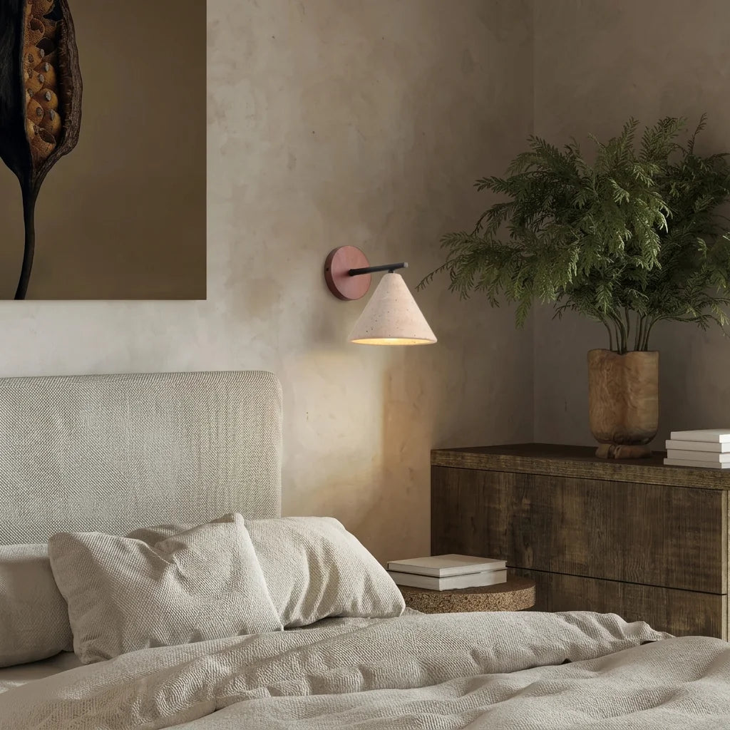 Travertin lámpa egy lenvászon ágy fölött, meszelt falon