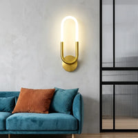 Arany LED hurok fali lámpa egy petróleumkék bársony kanapé fölött
