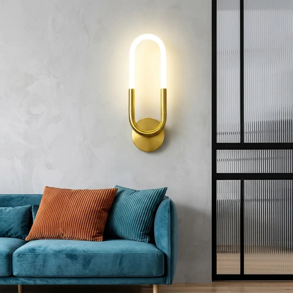 Arany LED hurok fali lámpa egy petróleumkék bársony kanapé fölött